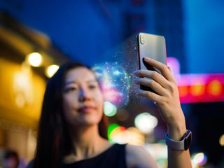 Asian woman using face recognition software via smartphone