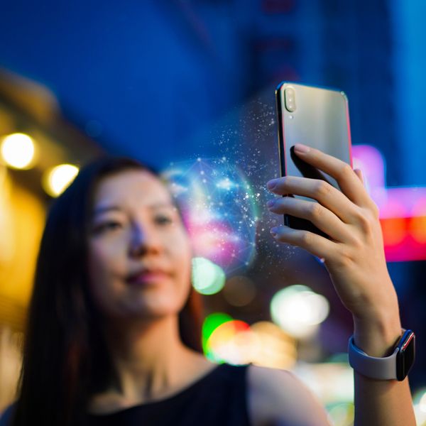 Asian woman using face recognition software via smartphone