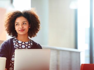 black-woman-having-coffee-sitting-on-a-table-with-computer