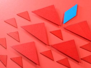 Blue rectangular wooden piece leading the other red wooden pieces