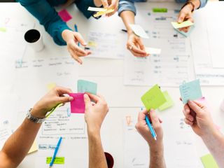 Colleagues using adhesive notes during meeting