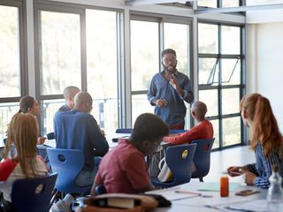 Male professor explaining topic to some students