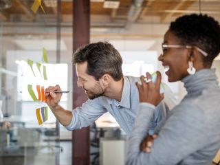 Man and woman brainstorming using adhesive notes