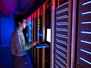 Man working on a server room in a datacenter