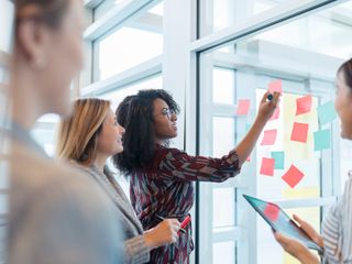 People at the office discussing over sticky notes