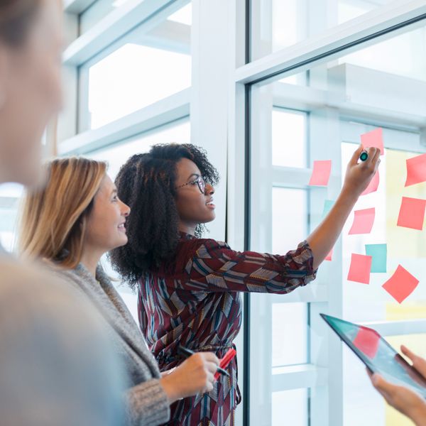 People at the office discussing over sticky notes