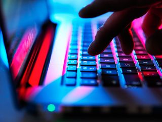 Person typing at his laptop computer at night