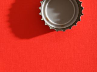 Straight down shot of bottle cap in red background