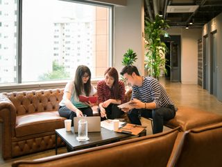Two women and man discussing a project in modern office