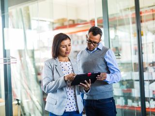 Woman and man discussing looking at a tablet