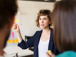 Woman explaining presentation to colleagues in office
