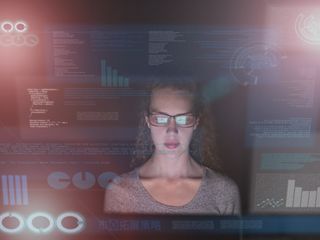 Woman in a dark room looking at data