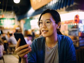 Woman using smartphone in a traditional style restaurant