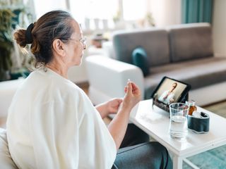 Woman video calling with female healthcare person