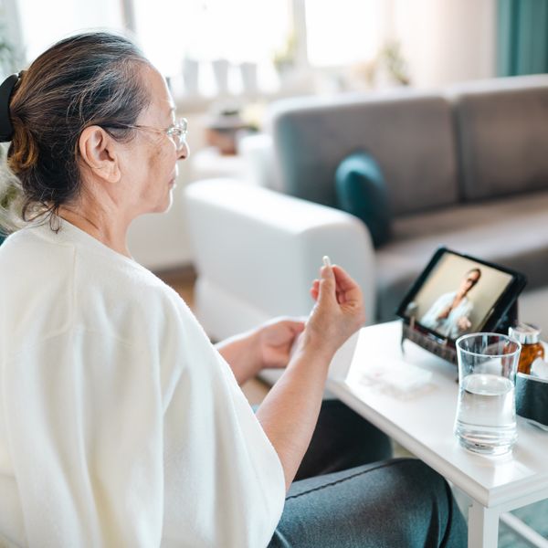 Woman video calling with female healthcare person