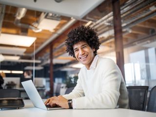 Smiling man at work with a laptop
