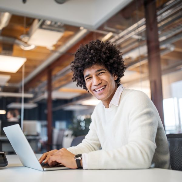 Smiling man at work with a laptop