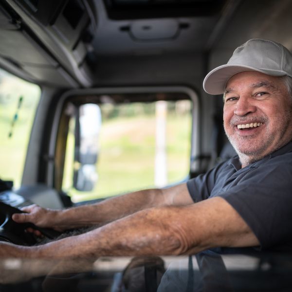 Truck driver sitting in cab and smiling to the camera