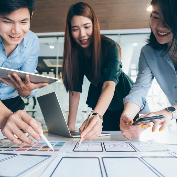 Two women and a man working together on drafts