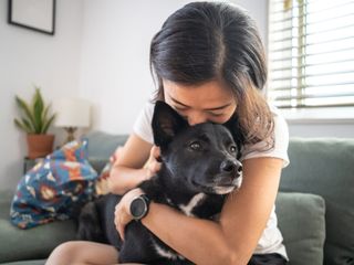 Woman hugging a dog on a couch