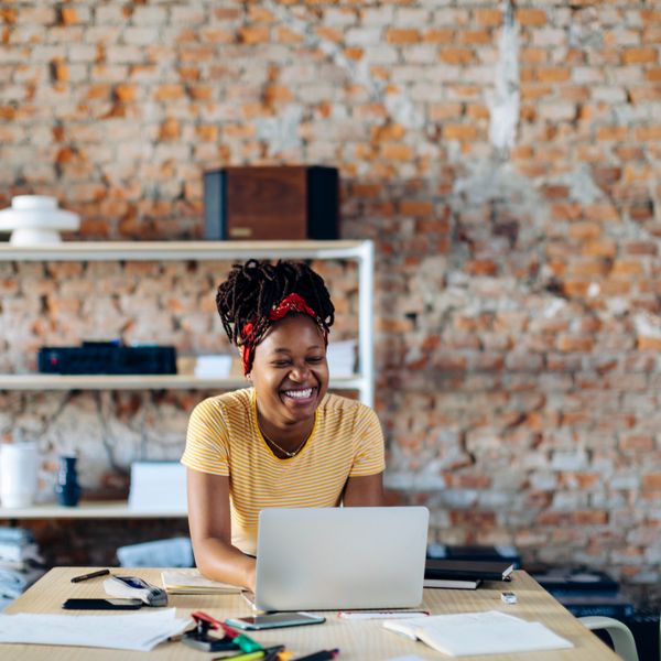 Woman smiling while sitting at table with laptop