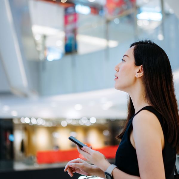 Woman using smartphone while shopping in a mall