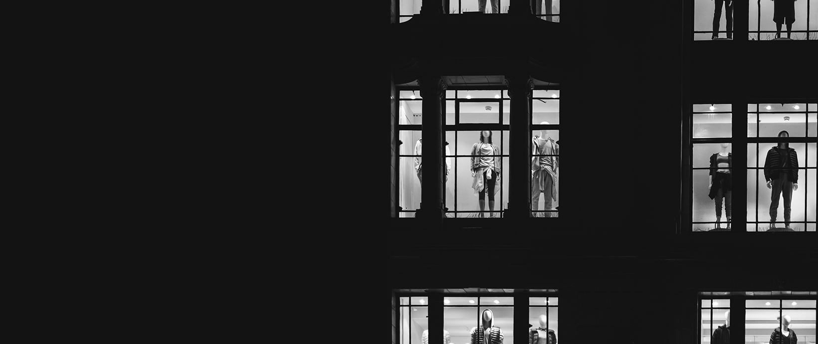 store mannequins seen through lit up store windows