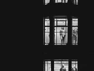 store mannequins seen through lit up store windows