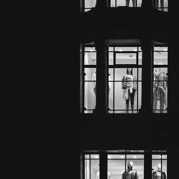 store mannequins seen through lit up store windows