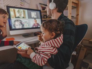 Man having video conference at home with his children around