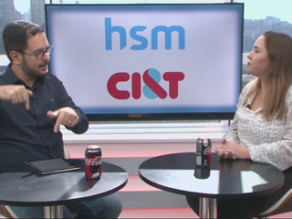 Um homem a direita, uma mulher a esquerda, conversando sentados 