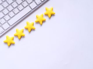 A keyboard in the top left corner of the image with 5 gold stars in front of it