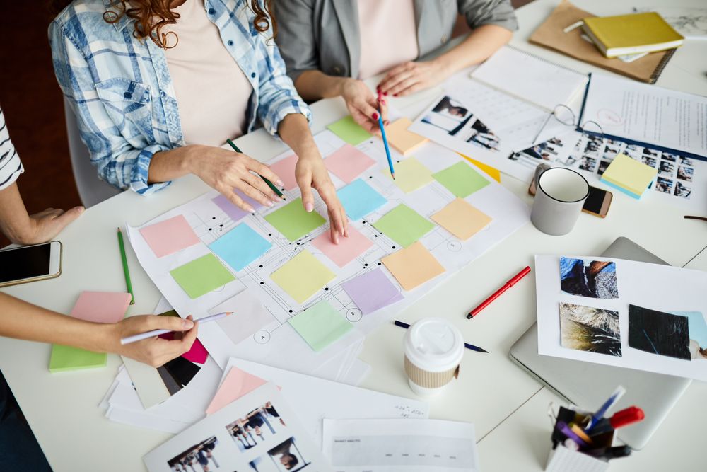 three women discussing over sticker notes