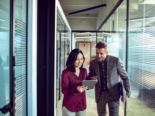 a woman and a man discussing over a tablet