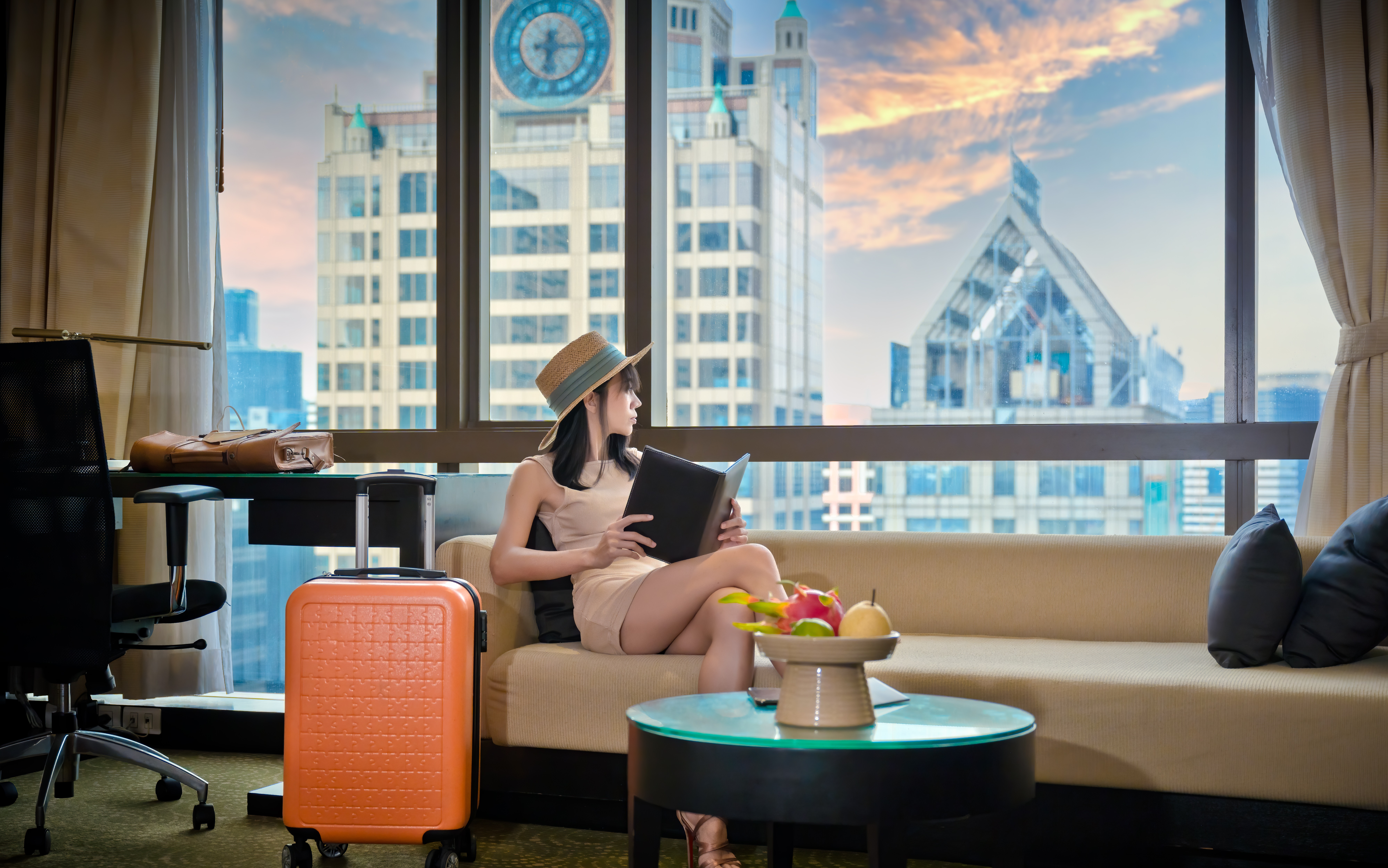 a woman in a hotel room looking outsite of the window