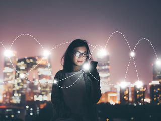 woman_holding_mobile_phone_on_urban_scenario