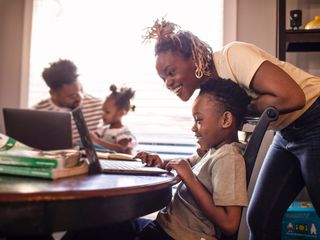Mother helping son during e-learning at home