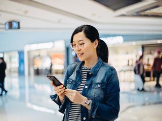 Mulher usando smartphone no shopping