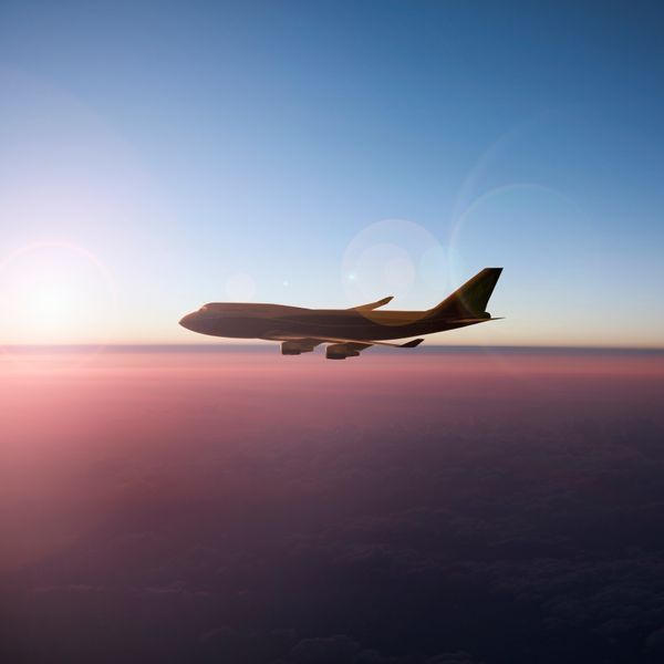 Airplane flying on sunset