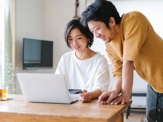 Man and woman using a credit card for internet shopping