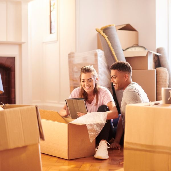 Couple smiling sitting on the floor around boxes