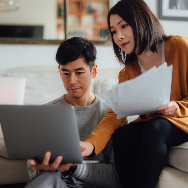 Man and woman smiling in front of a laptop