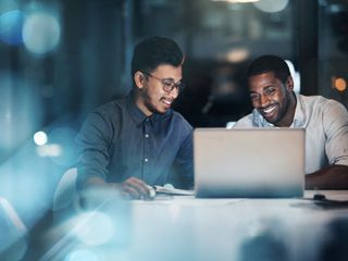 Two men in front of a laptop