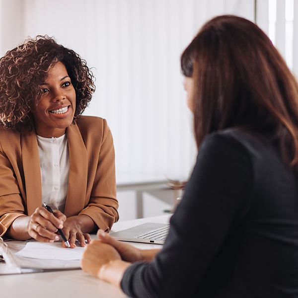 Two women sitting in front of each other having a conversation