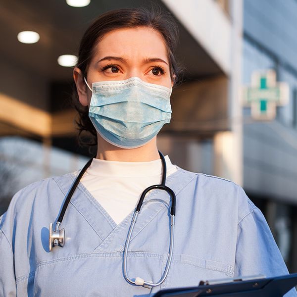 Doctor wearing mask in front of a hospital
