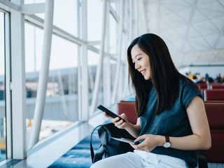 Woman holding passport and smartphone at the airport