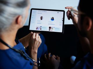 Two doctors looking at patient data on digital tablet