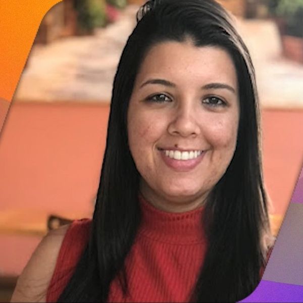 Rosto de Bianca Amorim, sobre um fundo com as cores do orgulho em degrad&ecirc;