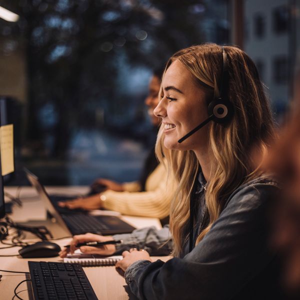 A smiling worker at her desk providing a great Customer Experience