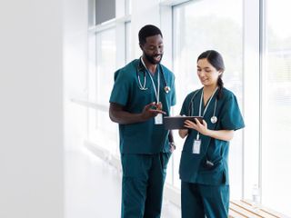 Two healthcare professionals looking at a tablet